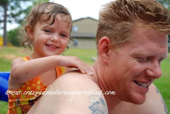 dad and daughter playing in the pool