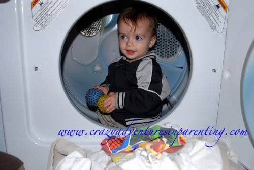 toddler playing in dryer