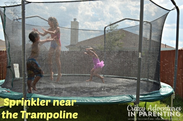 fun things to do with kids during summer vacation - sprinkler near the trampoline