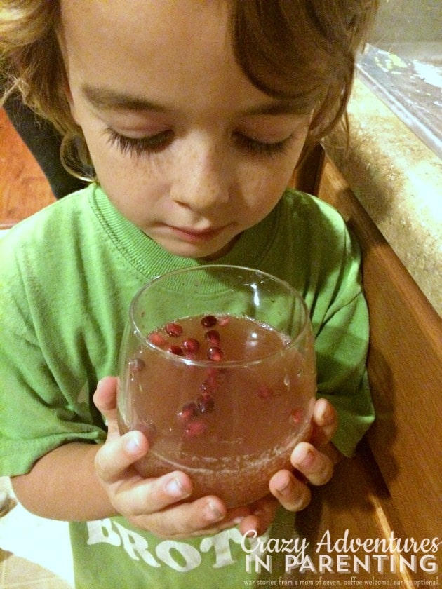 son holding sparkling juice mocktail