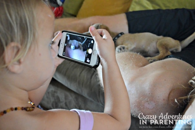 toddler snapping picture of puppy