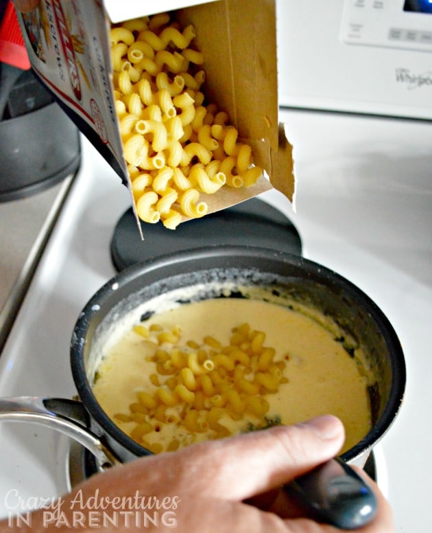 adding macaroni to cheese sauce
