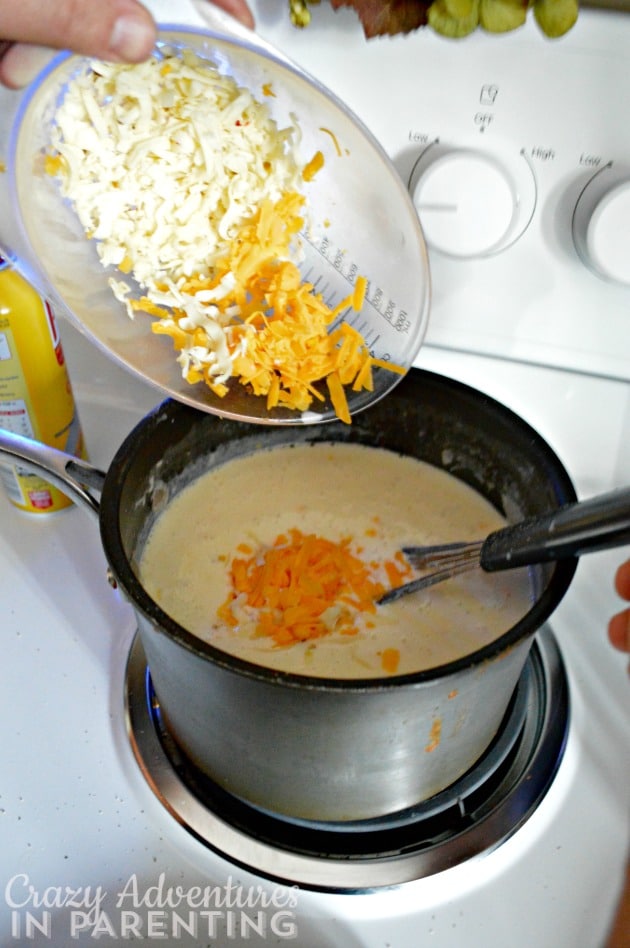 adding shredded cheese to sauce