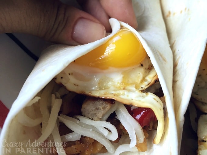 Sunny side up egg breakfast wrap about to burst, mmm