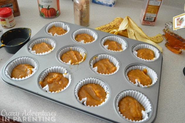 adding pumpkin pie mixture to the cupcake cups