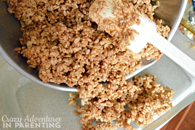 pouring crispy treats mixture into pan