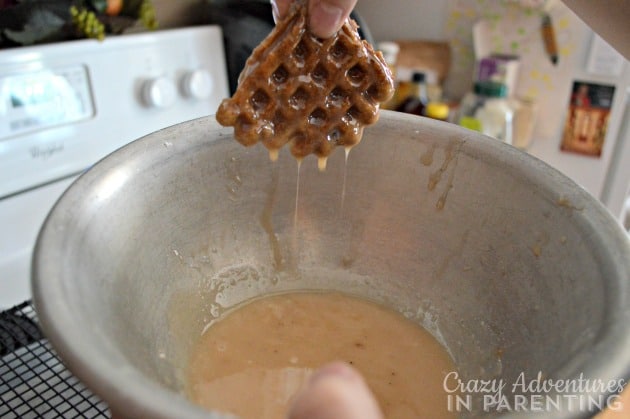 Glazed Apple Fritter Waffle Doughnuts soaking in glaze