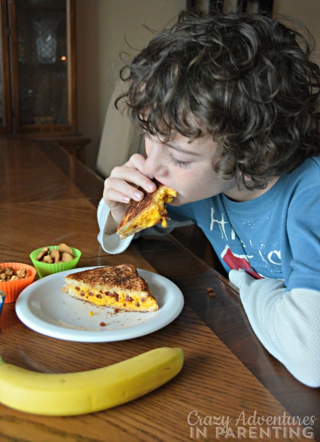 son eating his bacon macaroni and cheese grilled cheese