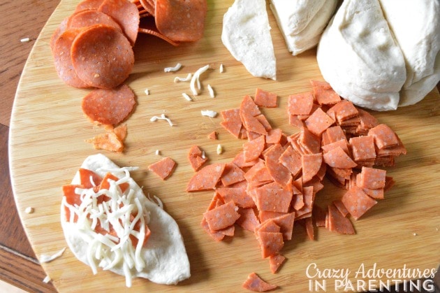 adding pizza ingredients to bread