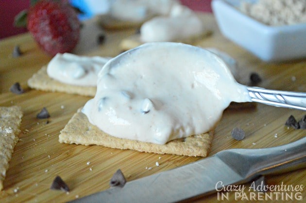 Spreading the Peanut Butter Chocolate Chip Yogurt onto the graham crackers