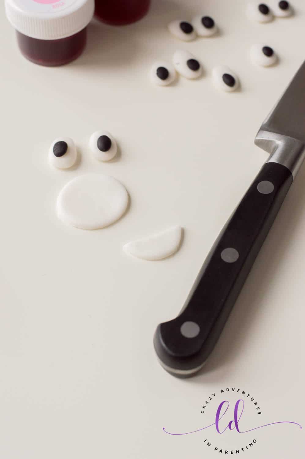 Cut out fondant smile for Tie-Dye Poop Emoji Cupcakes