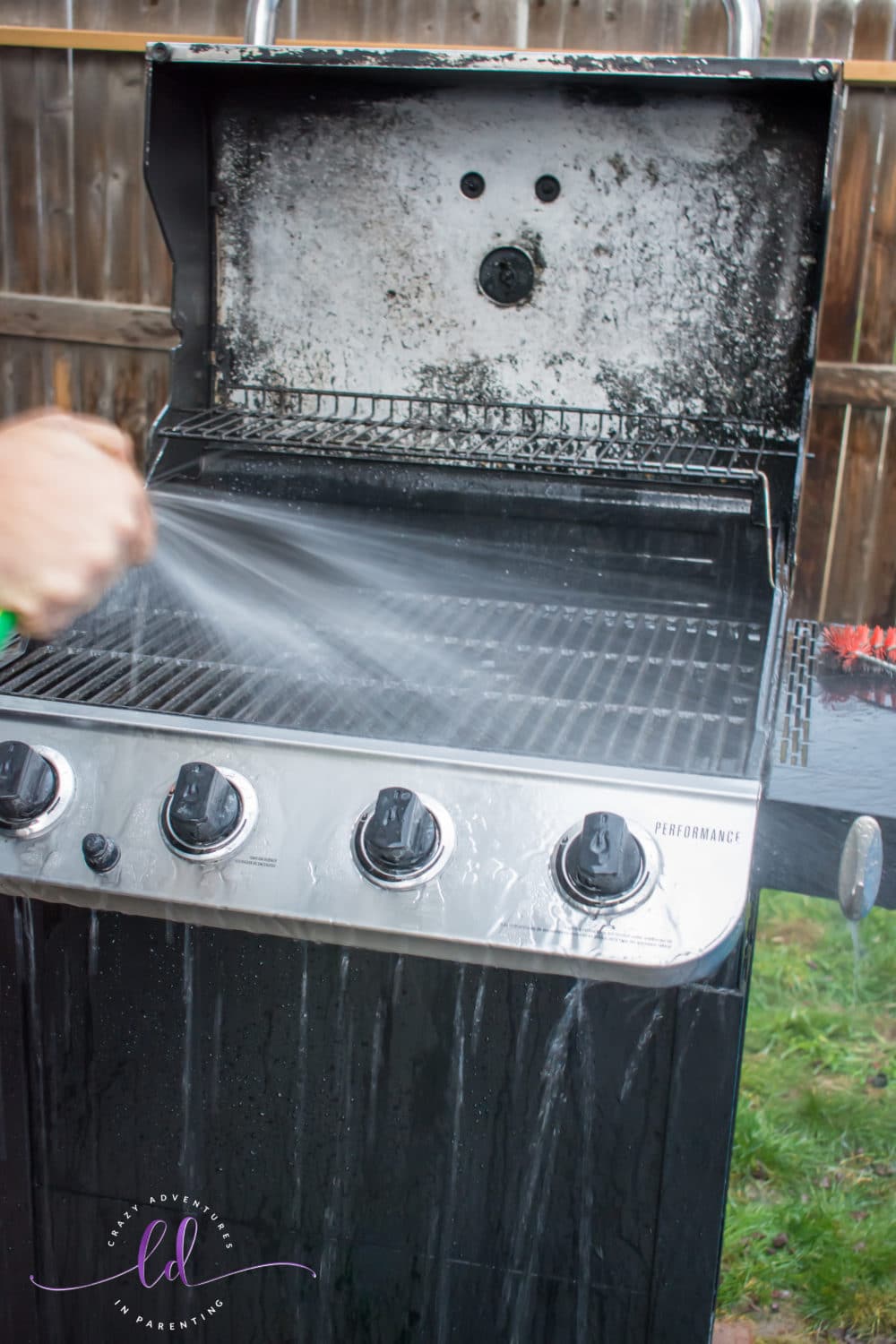 Rinsing Goo Gone Grill and Grate Cleaner off the grill