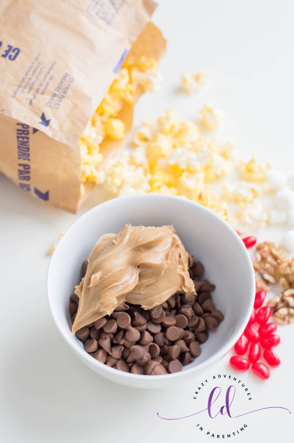 Put peanut butter and chocolate chips into bowl for Christmas Popcorn