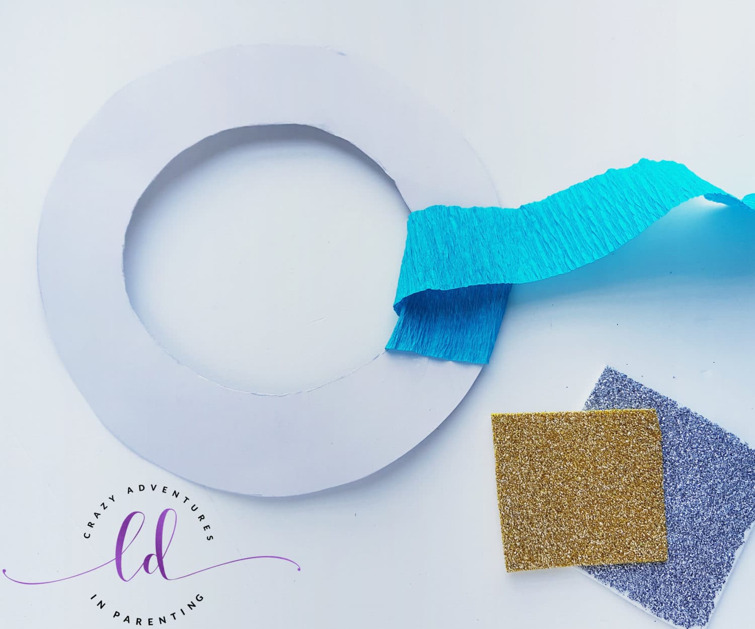 Begin Wrapping Crepe Paper Around Wreath Base to Make This Easy Frozen Wreath Craft