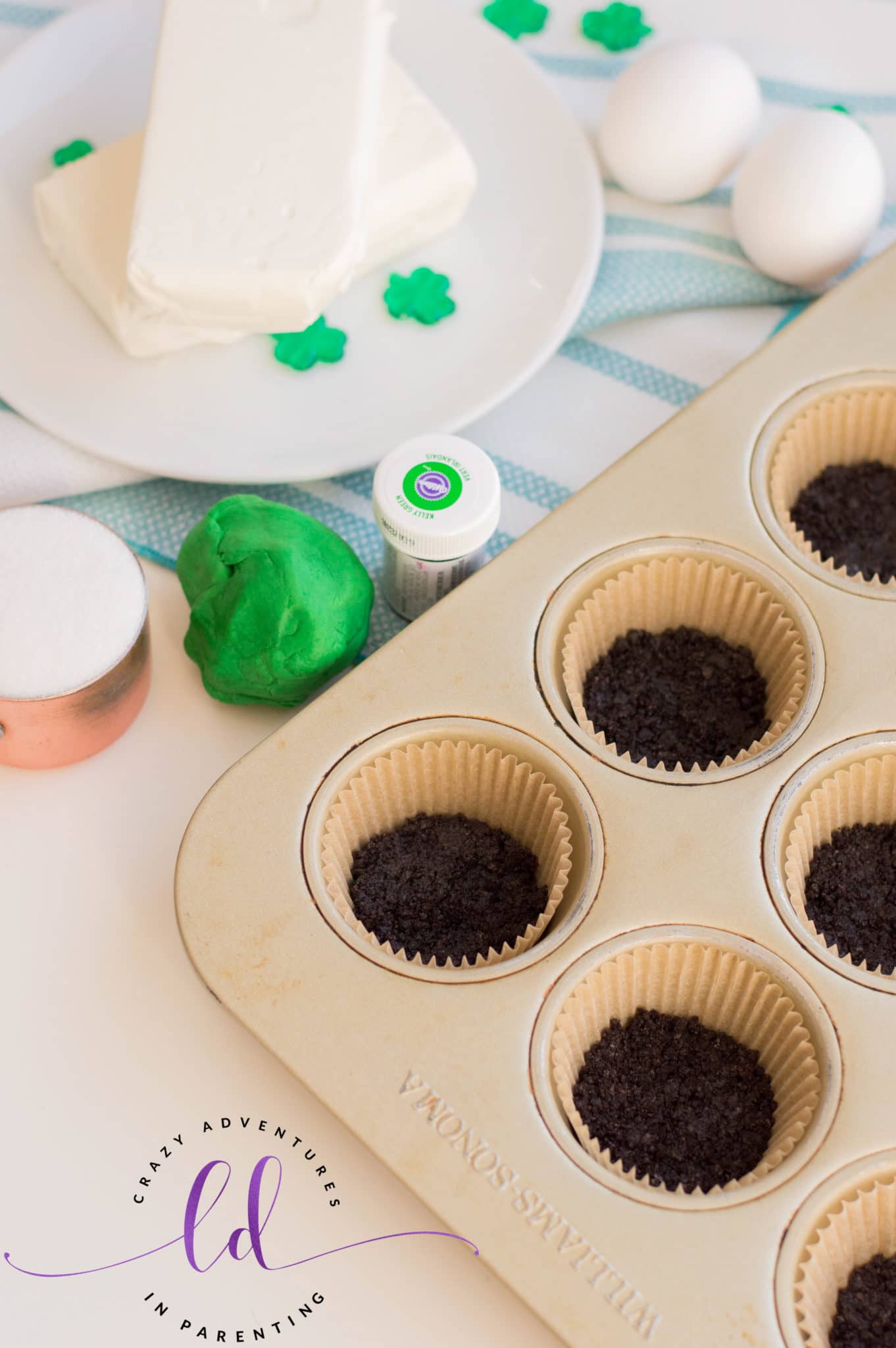 Line Muffin Pans with Oreo Crumbles for St. Patrick's Day Mini Cheesecakes