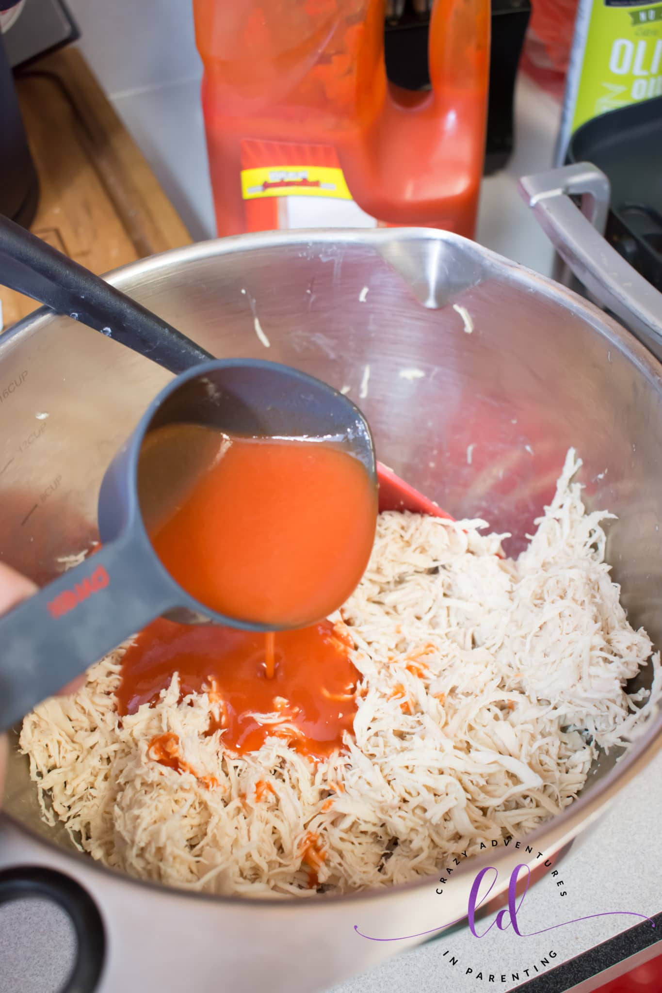 Pour Buffalo Sauce onto Shredded Chicken to Make Buffalo Chicken Bacon Ranch Quesadillas