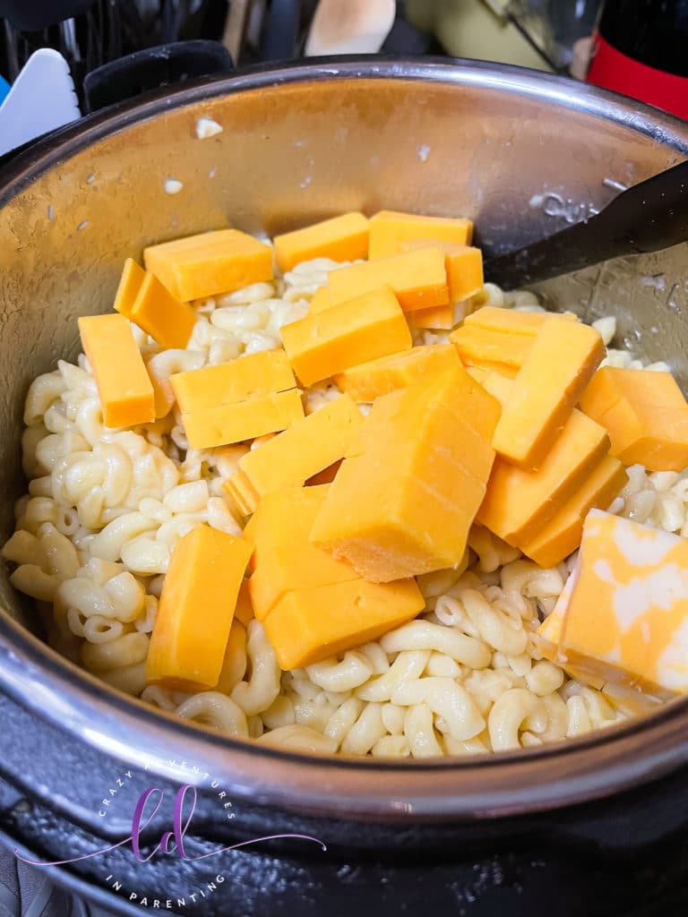 Add cubed cheese to the pot to make Instant Pot Queso Macaroni and Cheese
