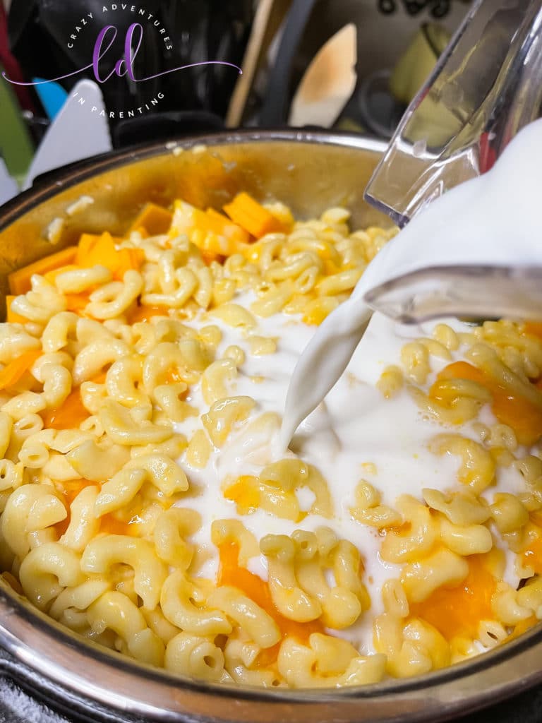 Add milk to pot to make Instant Pot Queso Macaroni and Cheese