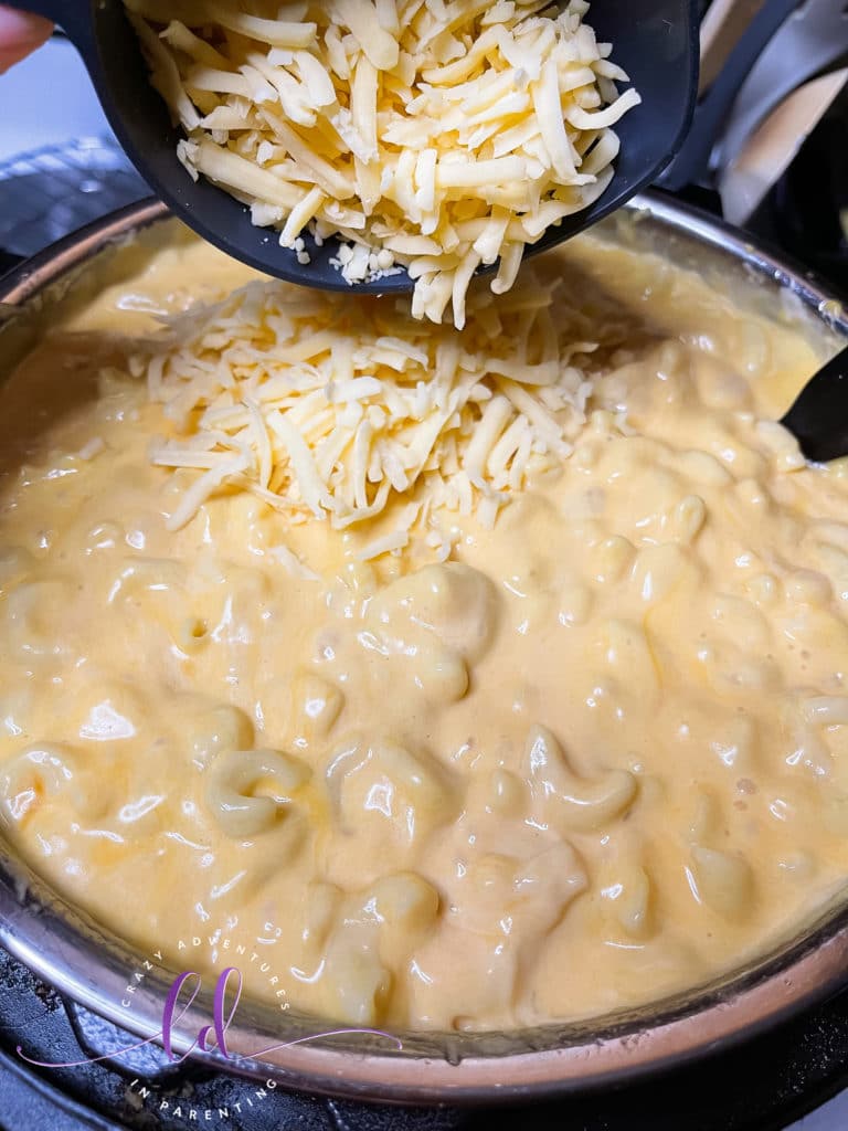 Add queso shredded cheese to the pot to make Instant Pot Queso Macaroni and Cheese