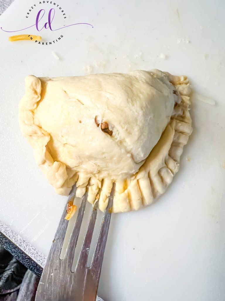 Seal the edge of the crescent roll dough with a fork to make Easy Beef Empanadas